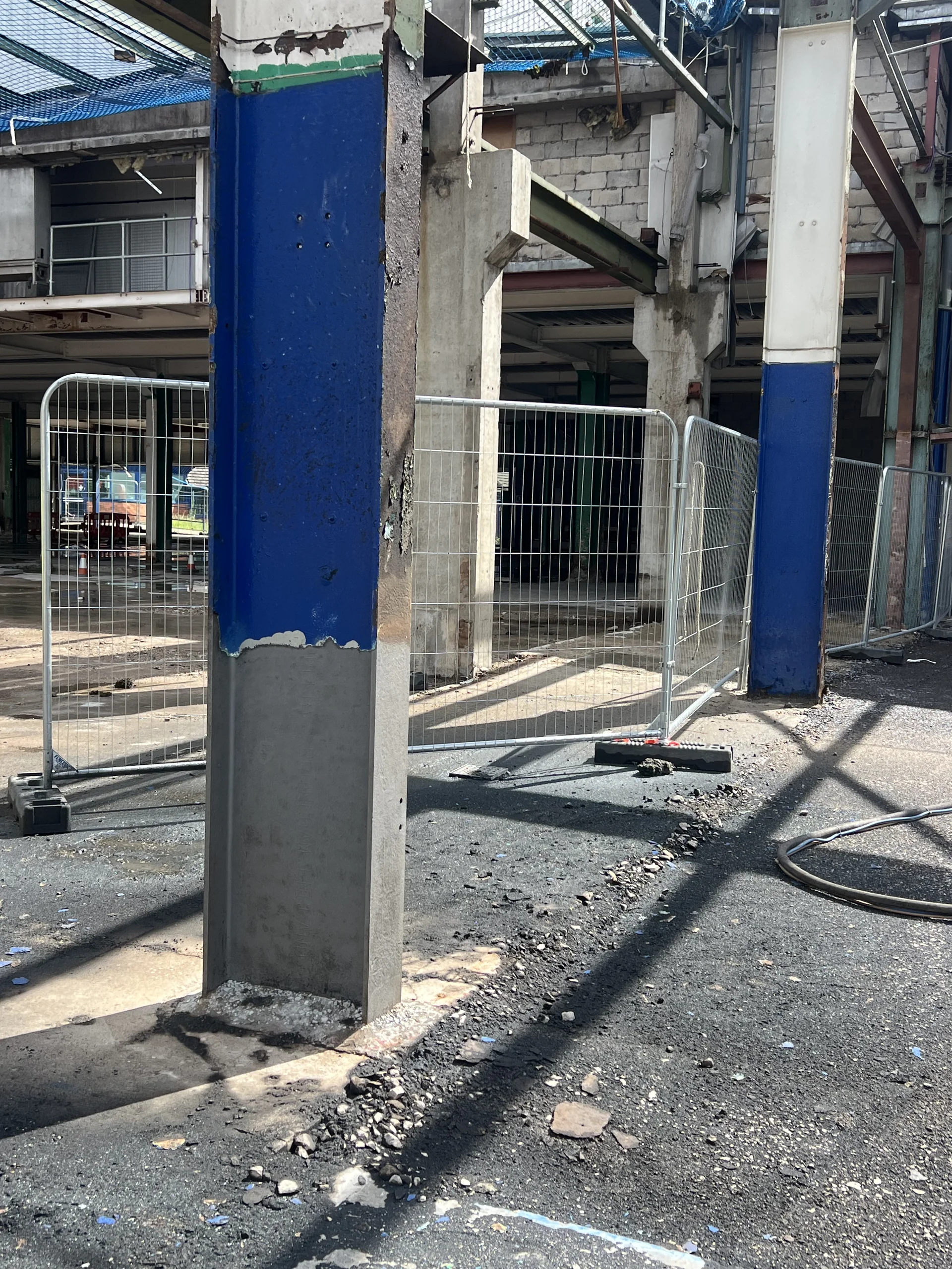 Prepared base section of a steel column beneath an existing blue coating