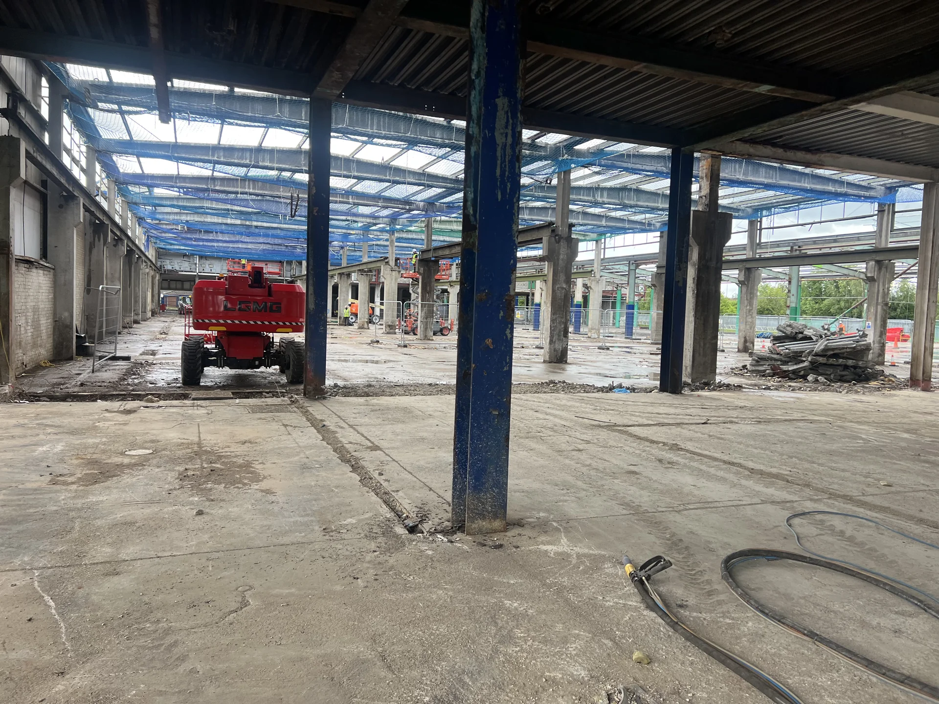 Wide interior view of a structural steel work area with columns and concrete floor