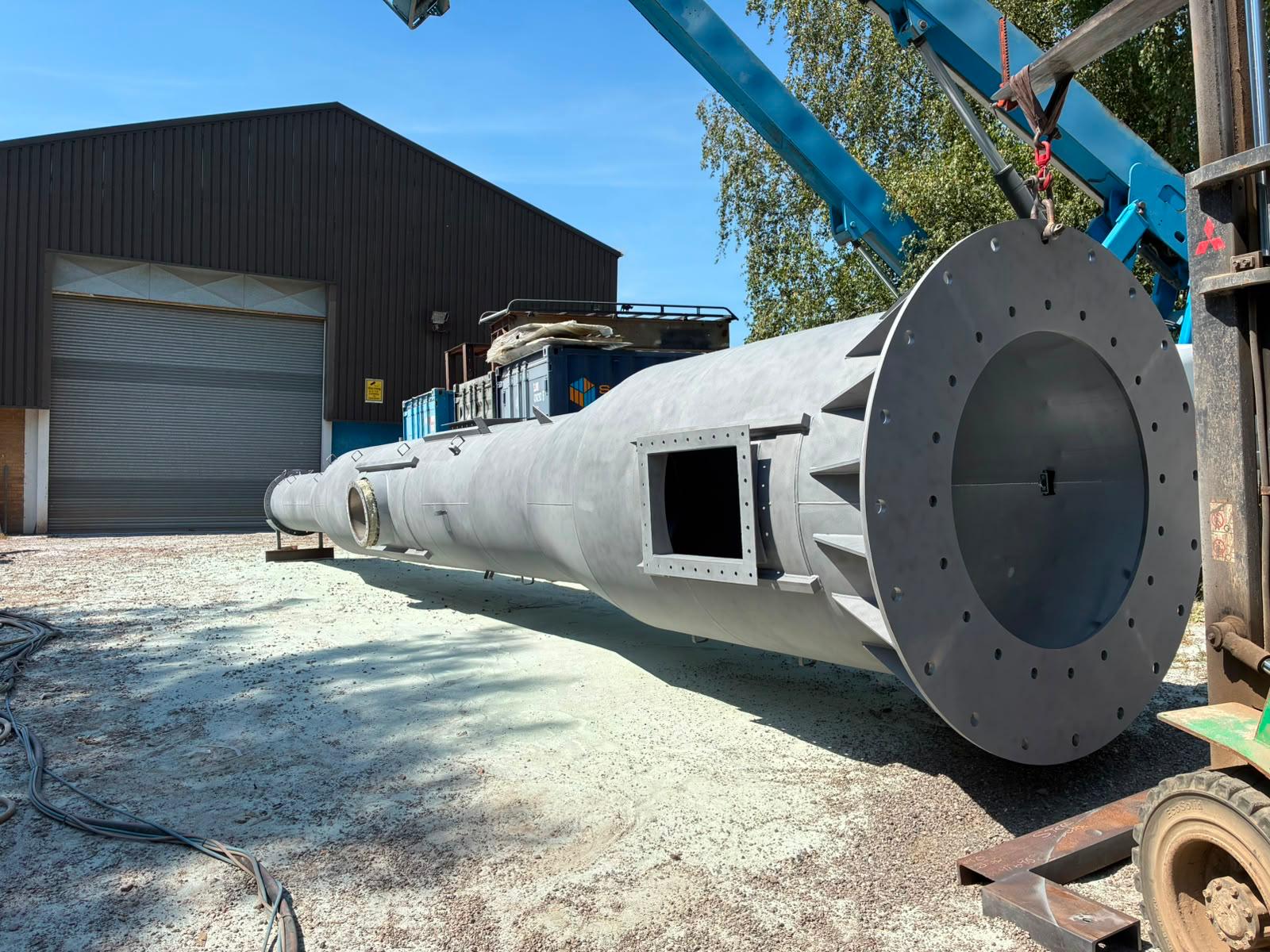Steel chimney after shot blasting — reinforced flange and access opening ready for the next stage