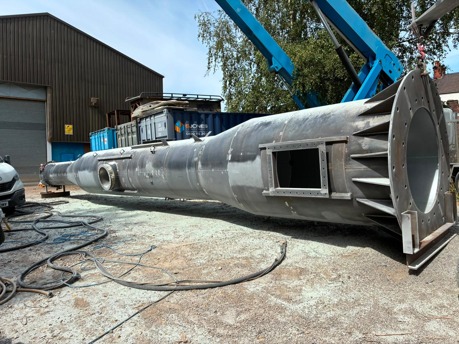 Steel chimney before shot blasting — large fabricated section, flange and access opening
