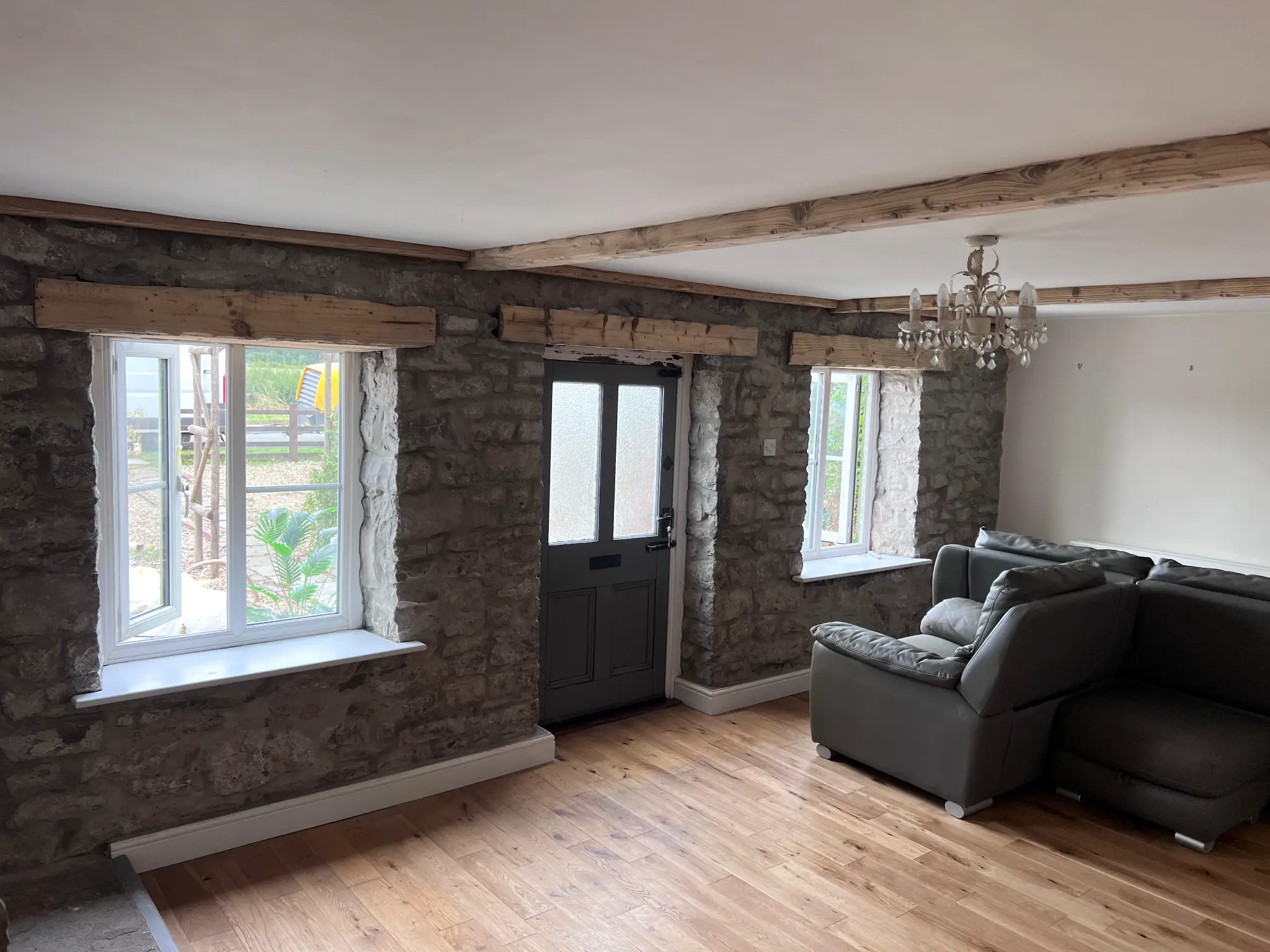 Natural timber beams and restored stonework in the main living space after restoration