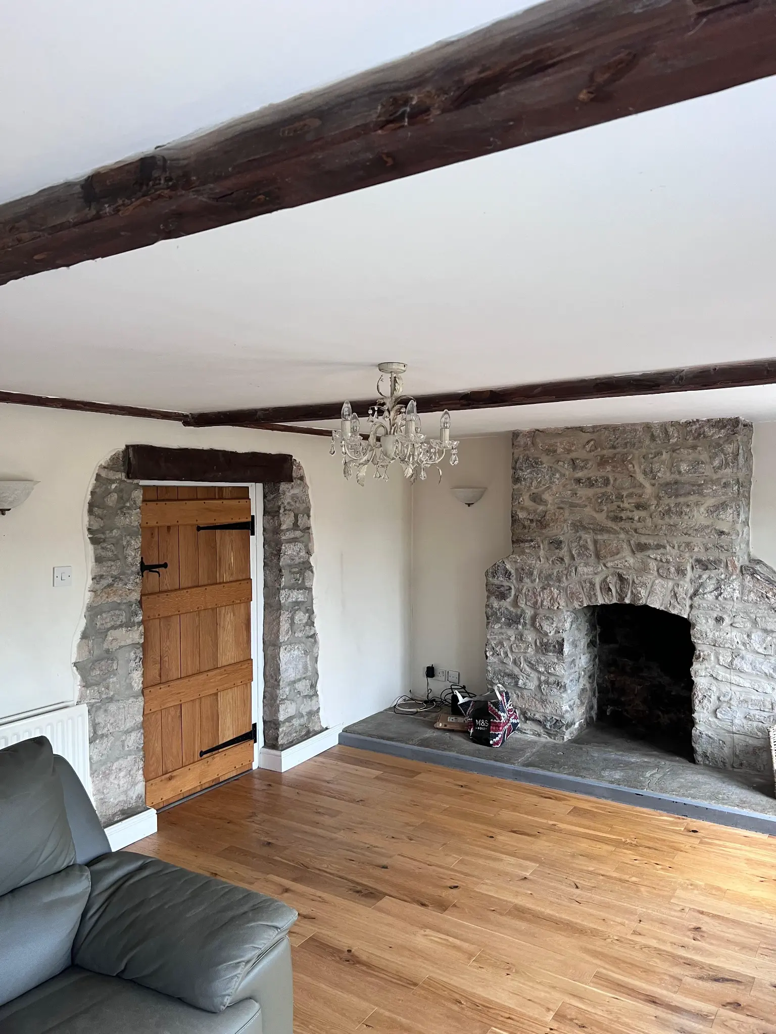 Dark-coated beams above the stone fireplace before restoration